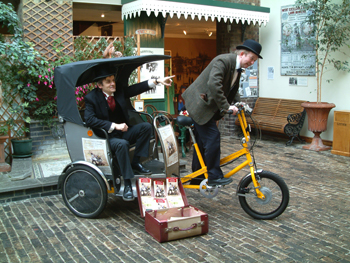 David Moger as Phileas Fogg and Graham Tuckwell as Passepartout travelled by rickshaw from Weston Super Mare library to the North Somerset museum and then on to the High Street, Weston Super Mare distributing copies of Around the World in Eighty Days.